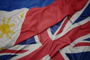 waving colorful flag of great britain and national flag of philippines.